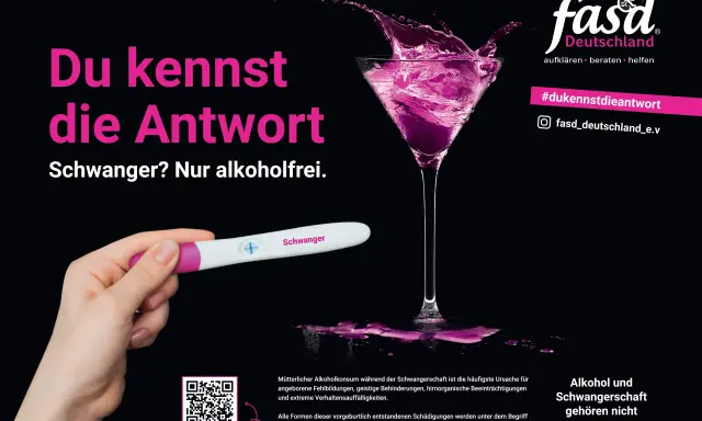Schwangerschaftstest zeigt positiv. Ein Glas mit pinkem Spritzer. Die Botschaft: Alkohol und Schwangerschaft gehören nicht zusammen.