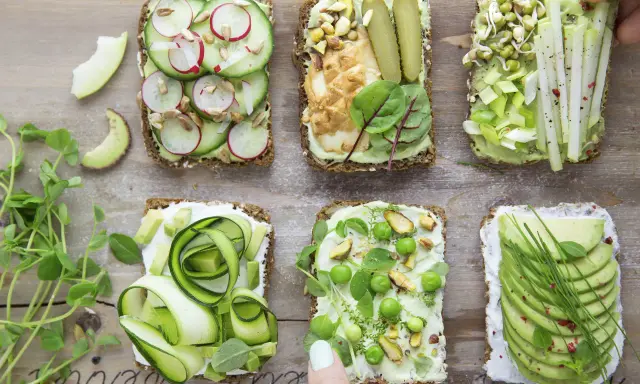 Sześć pysznych kanapek z awokado, ozdobionych warzywami, kiełkami i orzechami. Idealne na zdrowy lunch!