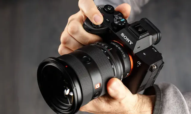 Mani che impugnano una Sony A7, obiettivo GM 2.8/24-70. Dettagli per la recensione.