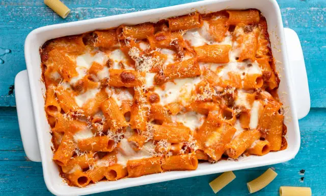 Un invitante piatto di pasta al forno con sugo rosso e formaggio filante, pronto per essere gustato.