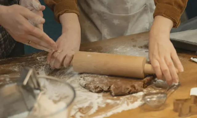 Mains farinées étalant une pâte à biscuits. Une question se pose : par quoi remplacer la farine de sarrasin pour une recette sans gluten ?