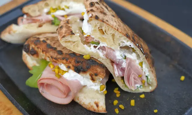 Gegrillte Pizza-Taschen gefüllt mit cremiger Ricotta, Mortadella und Pistazien.