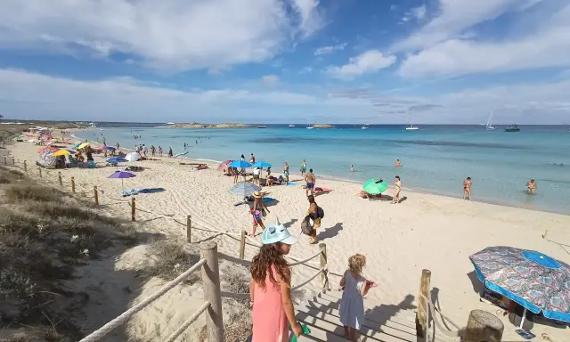 Giornata di sole a Formentera con bambini, tra sabbia bianca, mare cristallino e tante famiglie che si godono la vacanza.