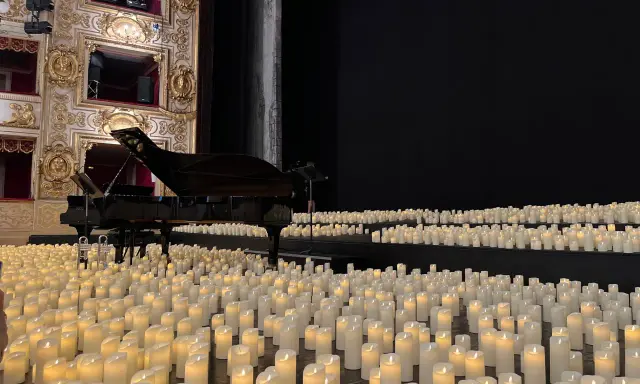 Un pianoforte su un palco ricoperto di candele, un'atmosfera magica di candlelight a Rimini.