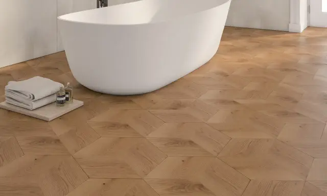 Bagno moderno con vasca freestanding e pavimento in parquet geometrico. Idee bagno con parquet per un tocco di calore e design.