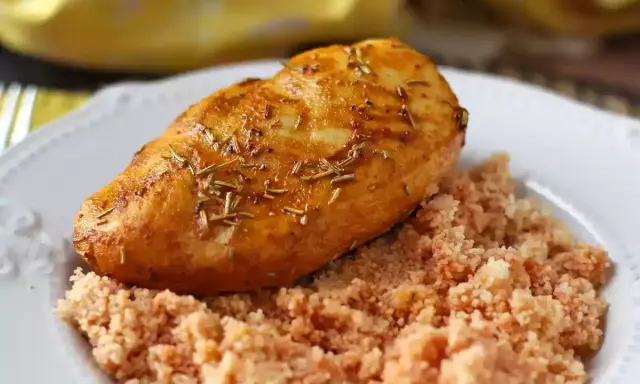 Petto di pollo in friggitrice ad aria, dorato e aromatico, servito su un letto di couscous.