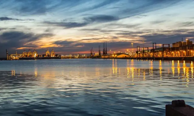 Tramonto sul porto di Southampton, con luci scintillanti e riflessi sull'acqua. Un'ottima vista per chi cerca cosa vedere a Southampton.