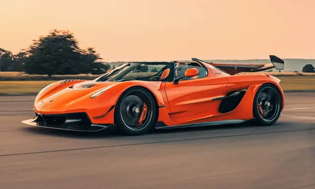 Ein orangefarbener Jesko von Koenigsegg rast auf einer Straße.