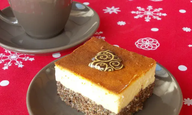 Seromakowiec z gotowej masy makowej i sera z wiaderka bez spodu, ozdobiony czekoladową choinką, obok filiżanki kawy na świątecznym obrusie.