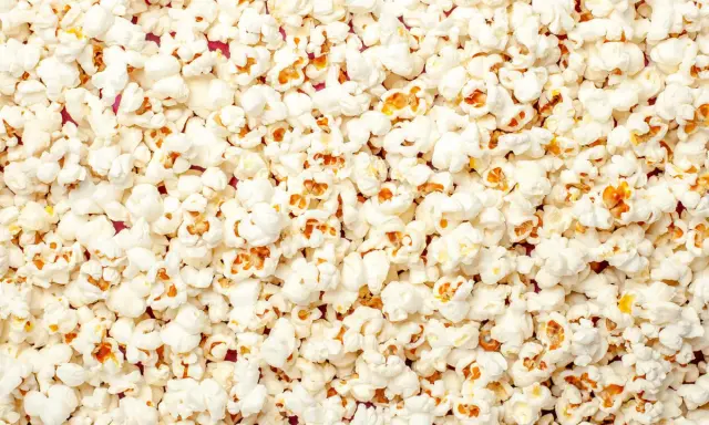 Mnóstwo puszystego popcornu, idealnego na wieczór filmowy. Czy pies może popcorn? Lepiej nie ryzykować, choć wygląda apetycznie!
