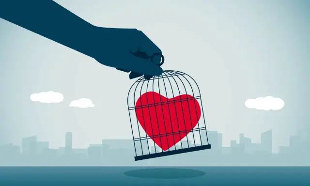 Mano che tiene una gabbia con un cuore rosso dentro, simbolo di esempi di manipolazione emotiva.