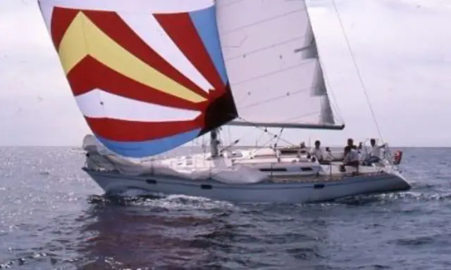 Un voilier avec une voile colorée, rappelant une légende du soleil, navigue sur une mer agitée. 41 avis sur cette aventure.