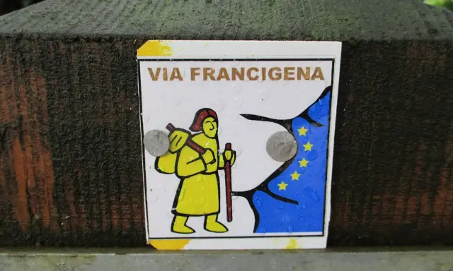 Segnale della Via Francigena, con un pellegrino stilizzato e la bandiera europea. Indica una delle tappe del cammino.
