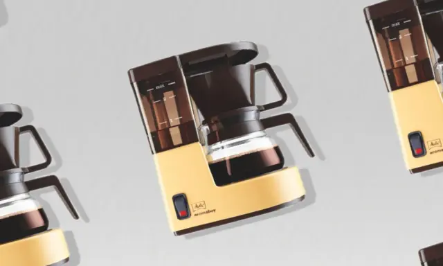 Retro-Kaffeemaschine in Gelb und Braun, bereit, köstlichen Kaffee zu filtern.
