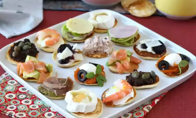 Plateau de blinis garnis de crevettes, saumon, fromage de chèvre, tapenade, jambon et autres délices.