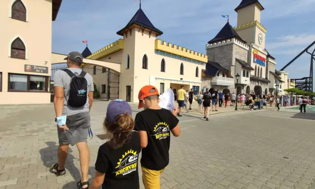 Familia paseando por un parque temático en Polonia con niños.