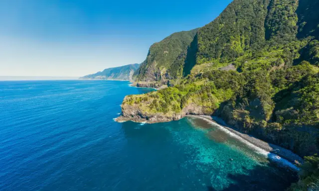 Grüne Berge treffen auf türkisfarbenes Meer. Ein perfekter Ort, um Madeira zu erleben.