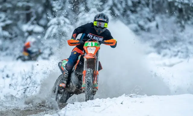 Motocyklista w akcji podczas wyścigu enduro w zimowej scenerii. To właśnie jest **enduro co to** za sport!