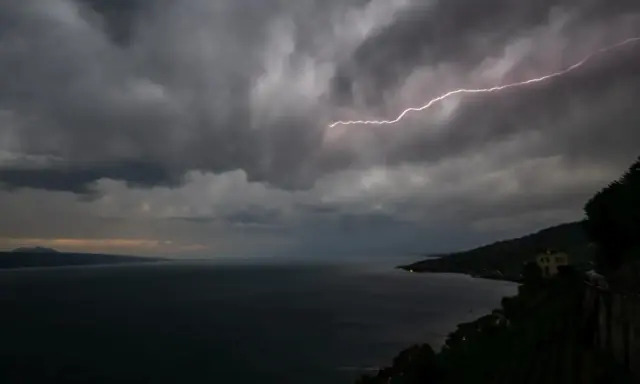 Éclair zébrant le ciel sombre au-dessus du lac Léman, annonçant une violente tempête.