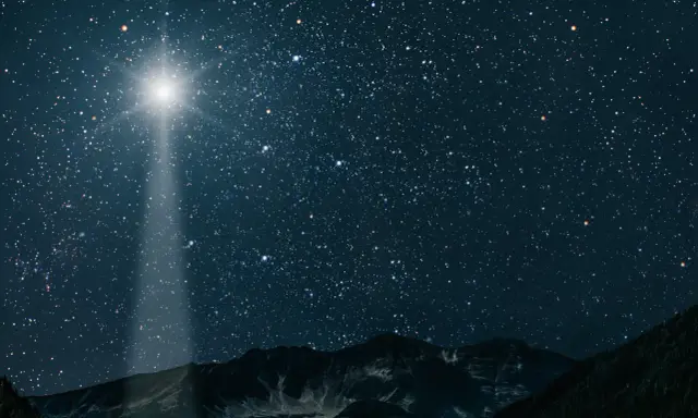 Jasna gwiazda betlejemska świeci na nocnym niebie nad górami, wskazując drogę.