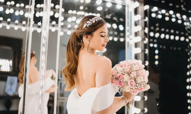Novia con peinados de novia recogidos elegantes, tiara brillante y ramo de rosas.