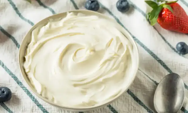 Un bol de chantilly mascarpone onctueuse, garni de fraises et de myrtilles. Parfait pour un dessert léger.