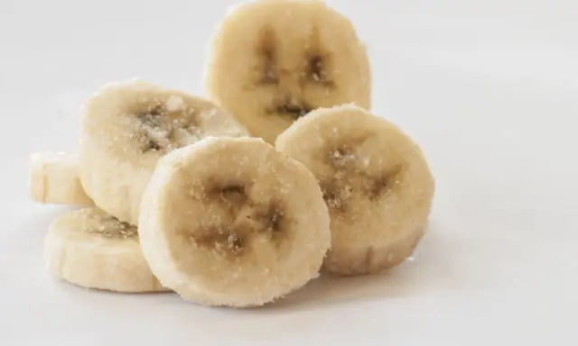 Ein Haufen gefrorener Bananenscheiben, bereit zum Einfrieren für Smoothies oder Desserts.