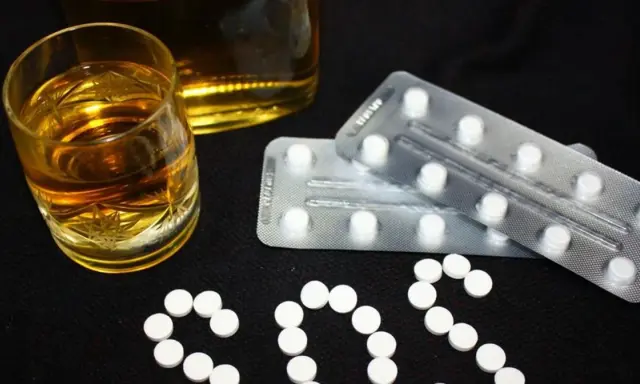 Szklanka alkoholu i blistry z tabletkami. Czy to pytanie o benzodiazepiny co to?