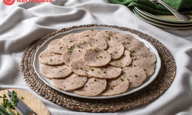 Rodajas de fiambre de pollo casero, decoradas con cebollino fresco, listas para disfrutar.