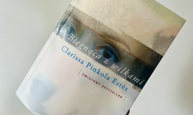 Książka "Biegnąca z wilkami" Clarissy Pinkoli Estés, światowy bestseller, z fragmentem oka na okładce.