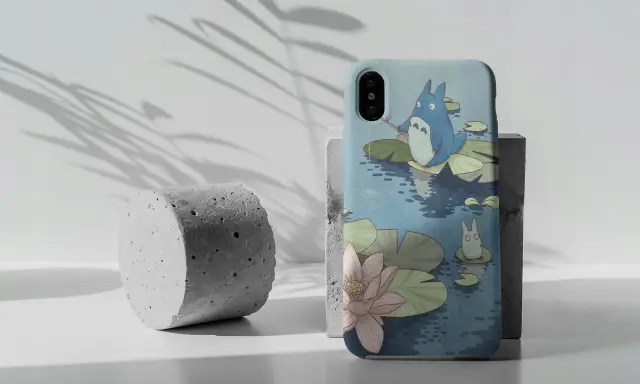 Urocze etui na Pixel 7 z Totoro łowiącym ryby na tle stawu z liliami wodnymi.