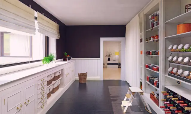 Przestronna spiżarnia w kuchni z białymi meblami, regałami pełnymi przetworów, win i nasion.