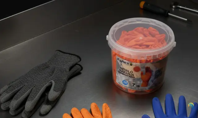 Guantes anticorte niveles de protección en gris y naranja, listos para tareas exigentes.