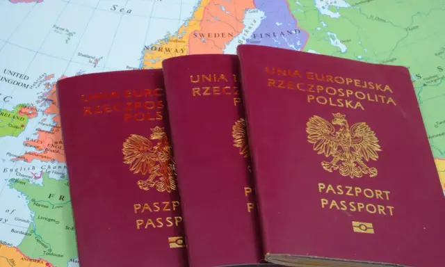 Trzy polskie paszporty leżą na mapie Europy. Czy do Grecji potrzebny jest paszport? Tak, jeśli podróżujesz spoza strefy Schengen.