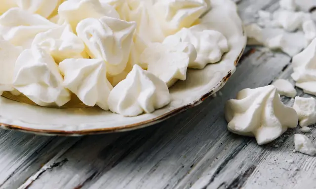 Douceur aérienne : des meringues comme celles de Cyril Lignac, croustillantes à souhait, sur une assiette vintage.