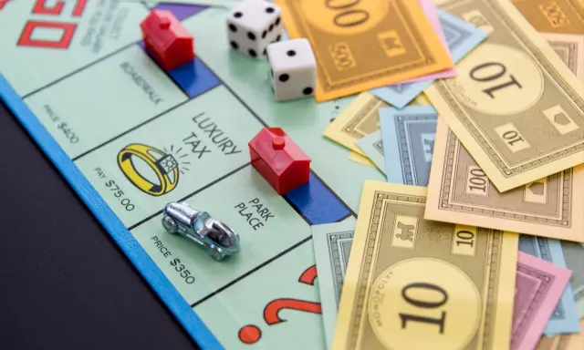 Na planszy Monopoly leżą pionki, kostki i banknoty. Czas na wielką rozgrywkę, ale gramy!