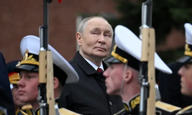 Władimir Putin w otoczeniu żołnierzy w mundurach, gdzieś w tle widać ceglany mur. To obraz, który przypomina o dawne słowo honoru.