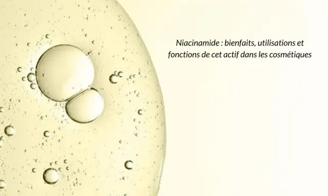 Gouttes dans un liquide clair, évoquant la pureté et les bienfaits de la niacinamide pour la peau.