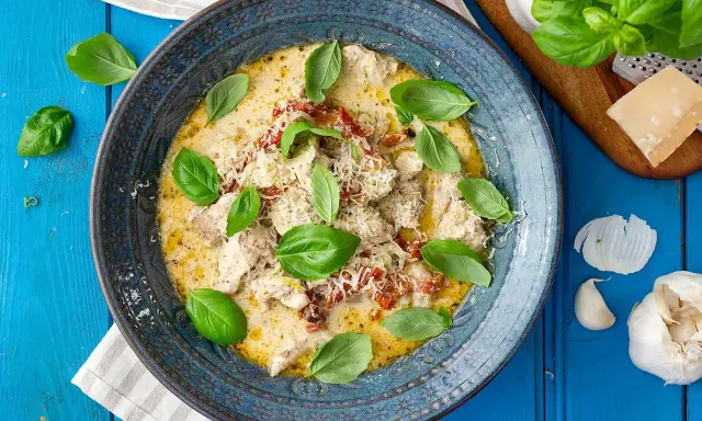 Krämig kyckling med soltorkade tomater, toppad med färsk basilika och parmesan. En härlig rätt som doftar Italien.