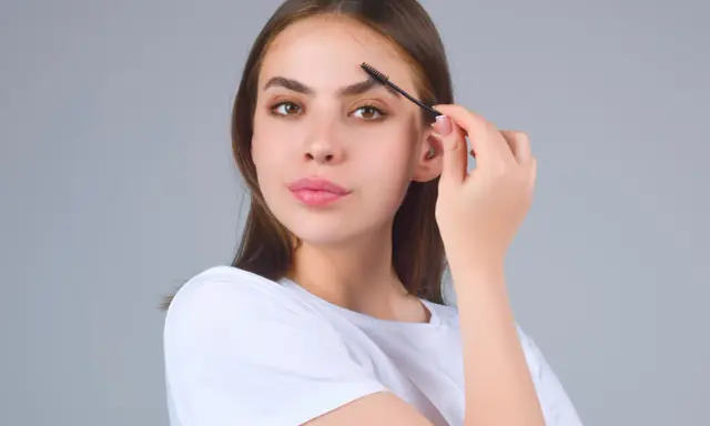 Jeune femme se brossant les sourcils. Une préoccupation pour la perte de sourcils avec l'âge, mais ici, ils sont parfaits.