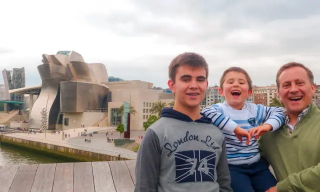 Familia disfrutando de un día en Bilbao con niños, con el icónico Museo Guggenheim de fondo.
