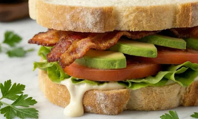 Ein BLT-Sandwich mit knusprigem Speck, saftigen Tomaten, cremigem Avocado und knackigem Salat auf getoastetem Brot.
