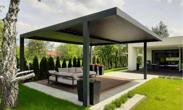 Nowoczesna pergola z wygodną sofą i stolikiem to idealne miejsce do wypoczynku. Zastanawiasz się, co położyć na taras? Tutaj widzisz gotową aranżację.