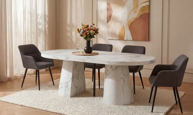 Ett elegant, marmorerat, långt matbord för 12 personer med mörka stolar och en vacker vas med blommor.
