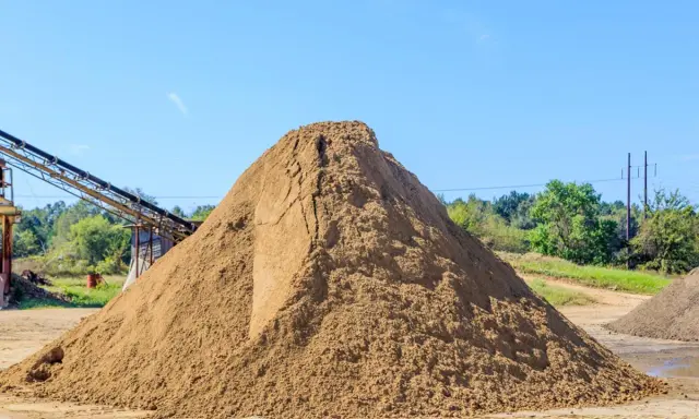 Ogromna hałda piasku, kluczowego składnika do produkcji betonu. Zastanawiasz się, ile piasku na m3 betonu? Tu jest go mnóstwo!
