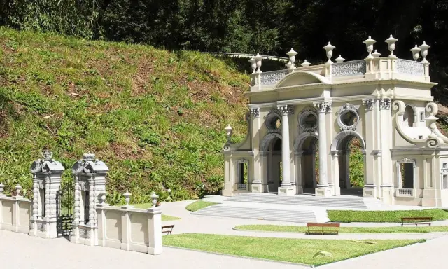 Miniaturowa budowla z kolumnami i bramą, jak w parku miniatur województwa mazowieckiego.