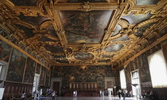 La salle du grand conseil du palais des doges, un chef-d'œuvre orné de peintures et de dorures, accueille des visiteurs émerveillés.