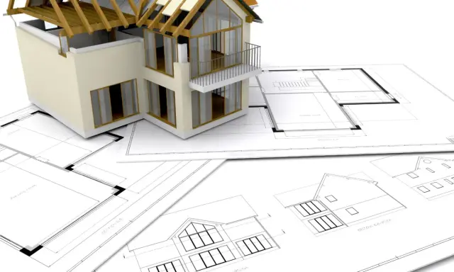 Model domu na planach architektonicznych. Zastanawiasz się, ile trwa budowa domu? To zależy od wielu czynników, ale zaczyna się od projektu.