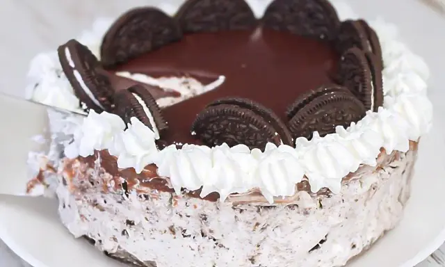 Delicioso pastel de oreo cubierto de chocolate y crema batida, decorado con galletas enteras.