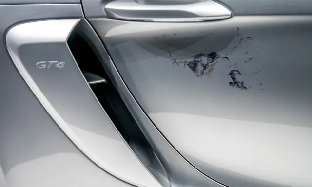 Na srebrnym lakierze Porsche GT4 schodzi lakier bezbarwny, tworząc nieestetyczne plamy. Jak naprawić ten problem?